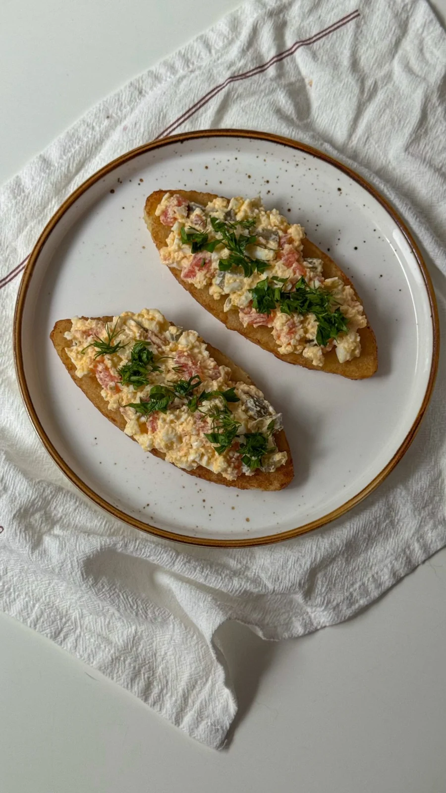 Хашбрауны с рыбой и яйцом на тарелке